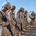 Soldiers bow their heads in respect during the opening prayer