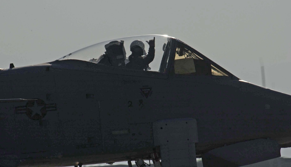 An A-10 Thunderbolt II pilot waves as he taxis for takeoff