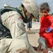 Capt. James helps an Iraqi girl try on a new pair of shoes