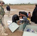 Capt. Ryan Mitcha watches as Iraqi mothers choose school supplie