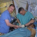 Maj. Reissenweber Works With a Soldier While They Aid a Patient