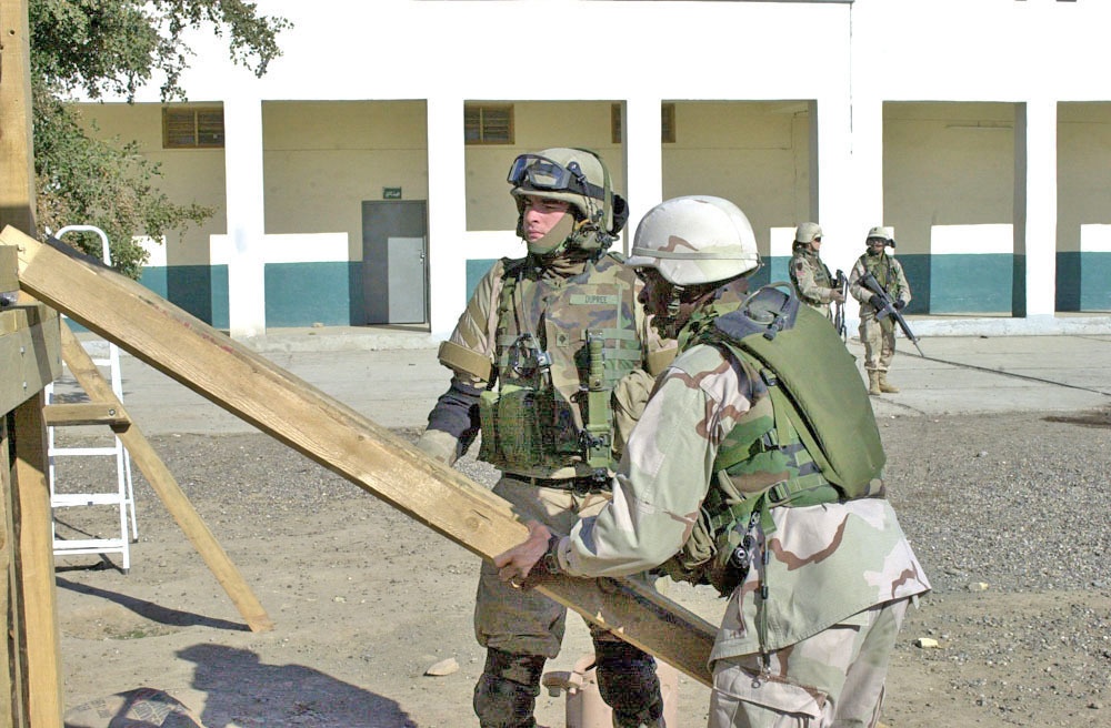 Soldiers installs steps for a playground system