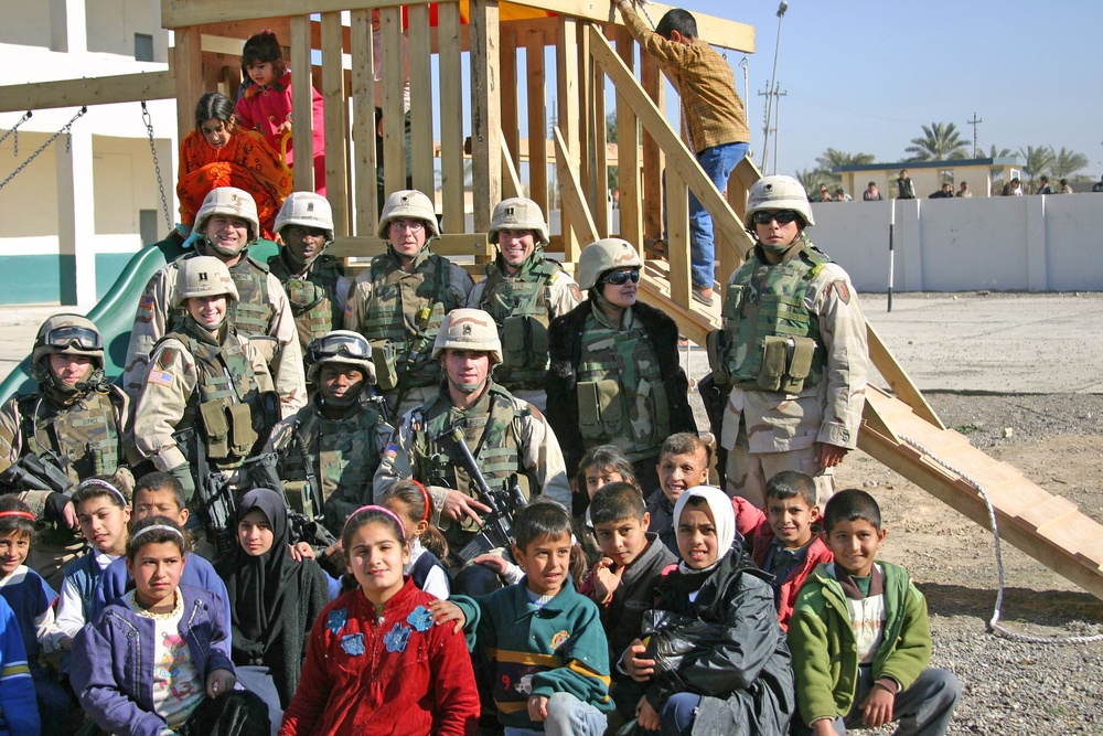 Soldiers pose in front of playground system