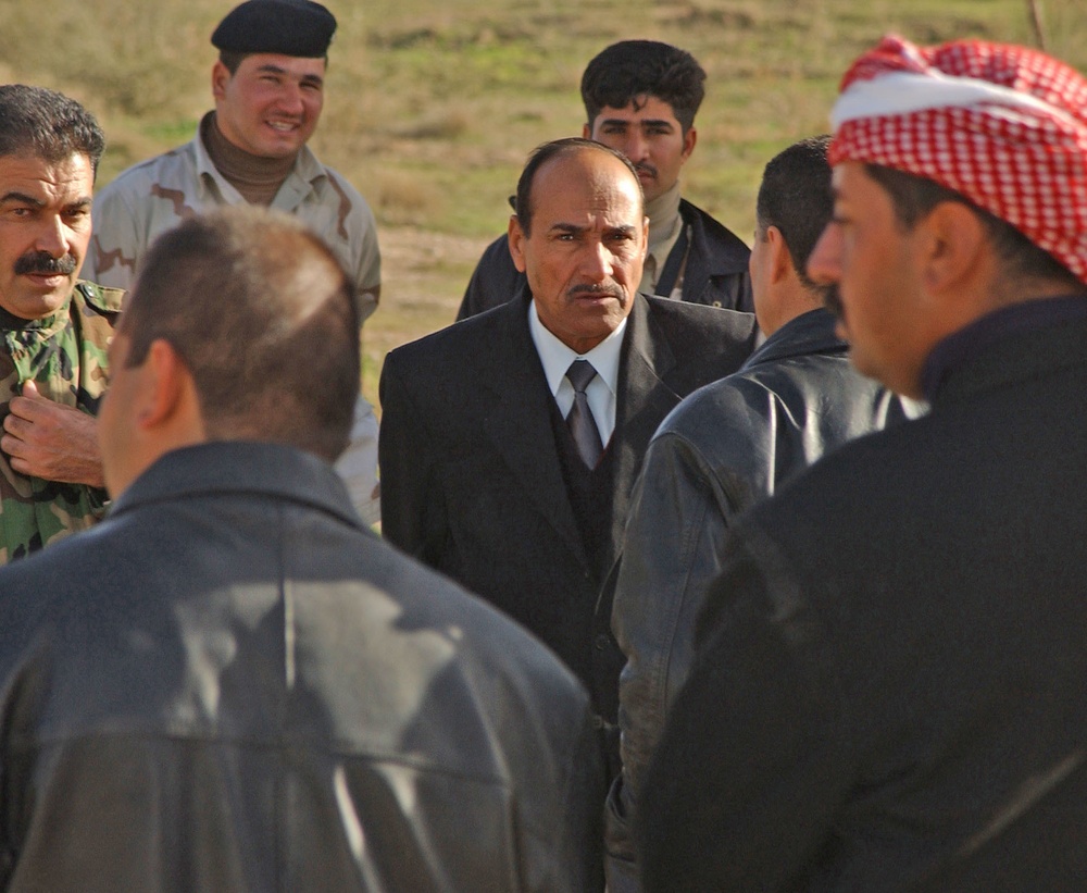 An Iraqi national talks with members of the Iraqi National Guard