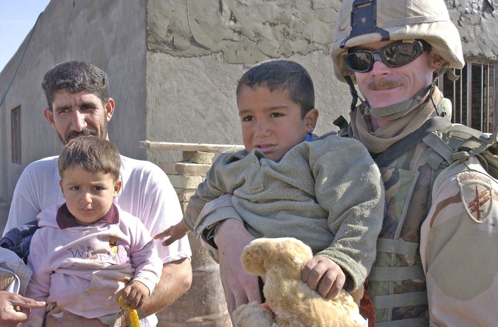 Sgt.Thomas poses for a picture with an Iraqi family