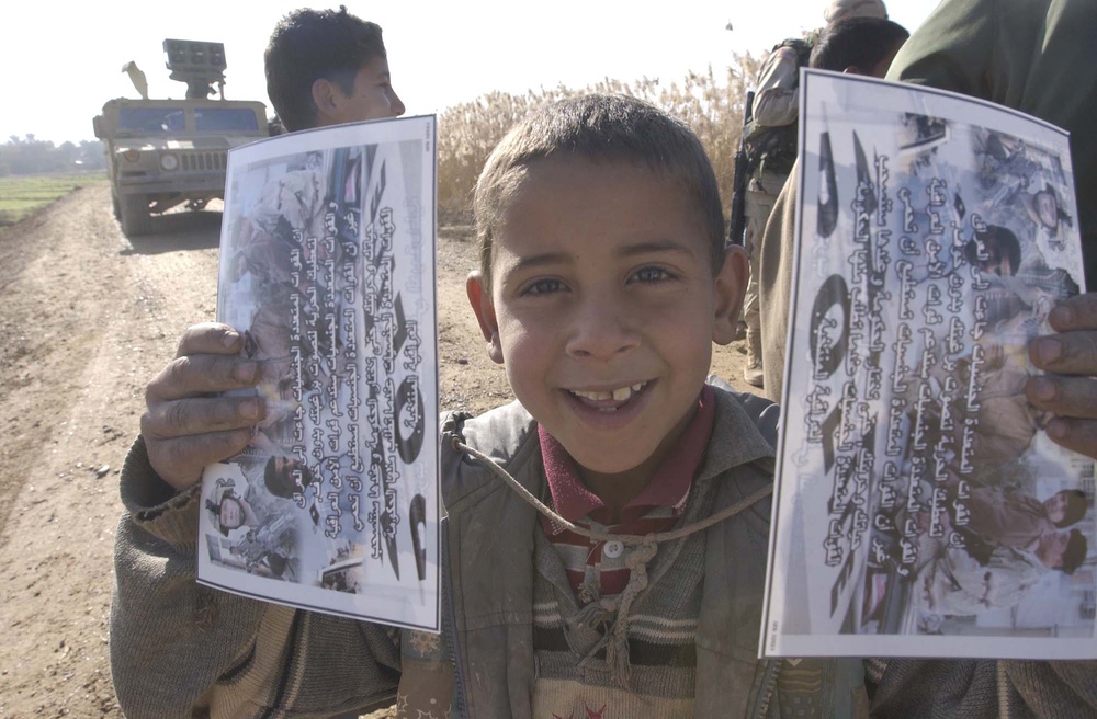 An Iraqi boy holds a flyer about the upcoming Iraqi elections
