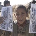 An Iraqi boy holds a flyer about the upcoming Iraqi elections
