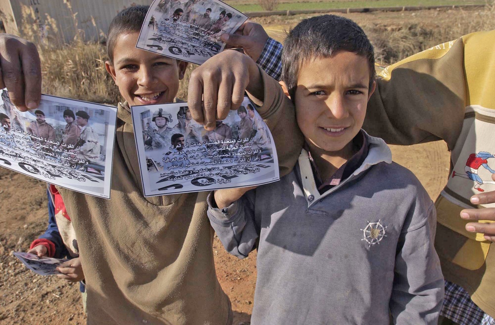 An Iraqi boy holds a flyer about the upcoming Iraqi elections