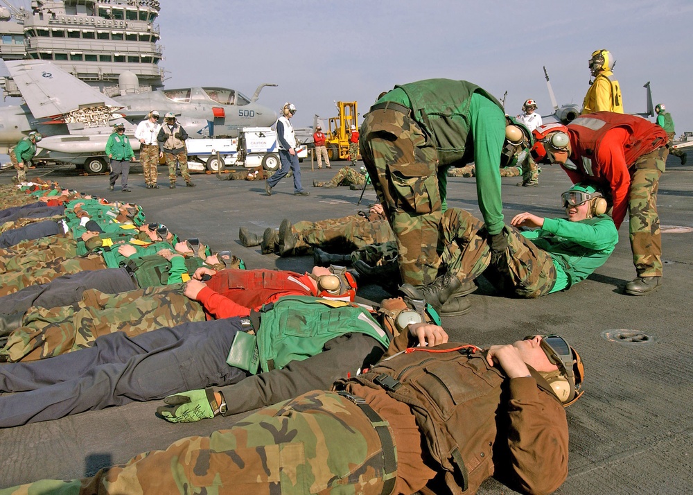Flight deck personnel move simulated casualties