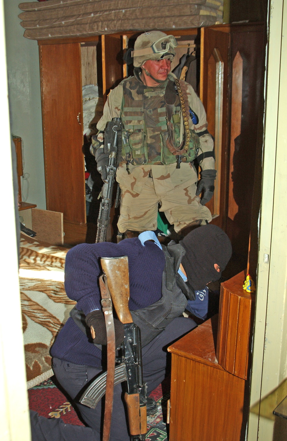 Spc. Azure and an Iraqi policeman search an apartment