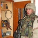 Spc. Montiel stands next to materials found in an apartment