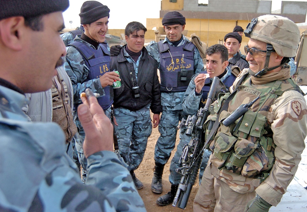 Sgt. Aziz Atakuziev interacts with a group of Iraqi Police offic