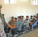 A soldier visits with some students of a school