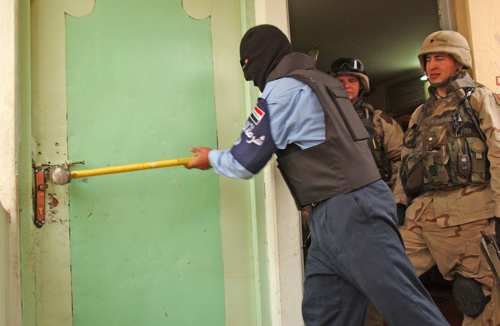 Spc. Montiel supervises as an Iraqi policeman