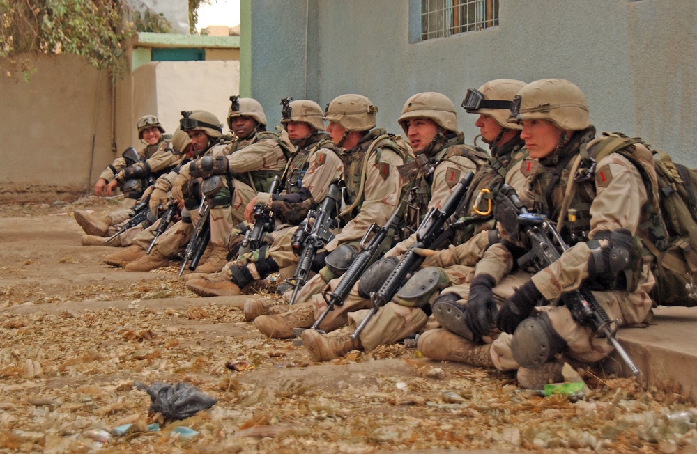 Soldiers rest and regroup outside a school