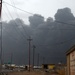 Smoke from an oil and brush fire darkens the sky