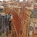 Soldiers search the yard of a known criminal in a village