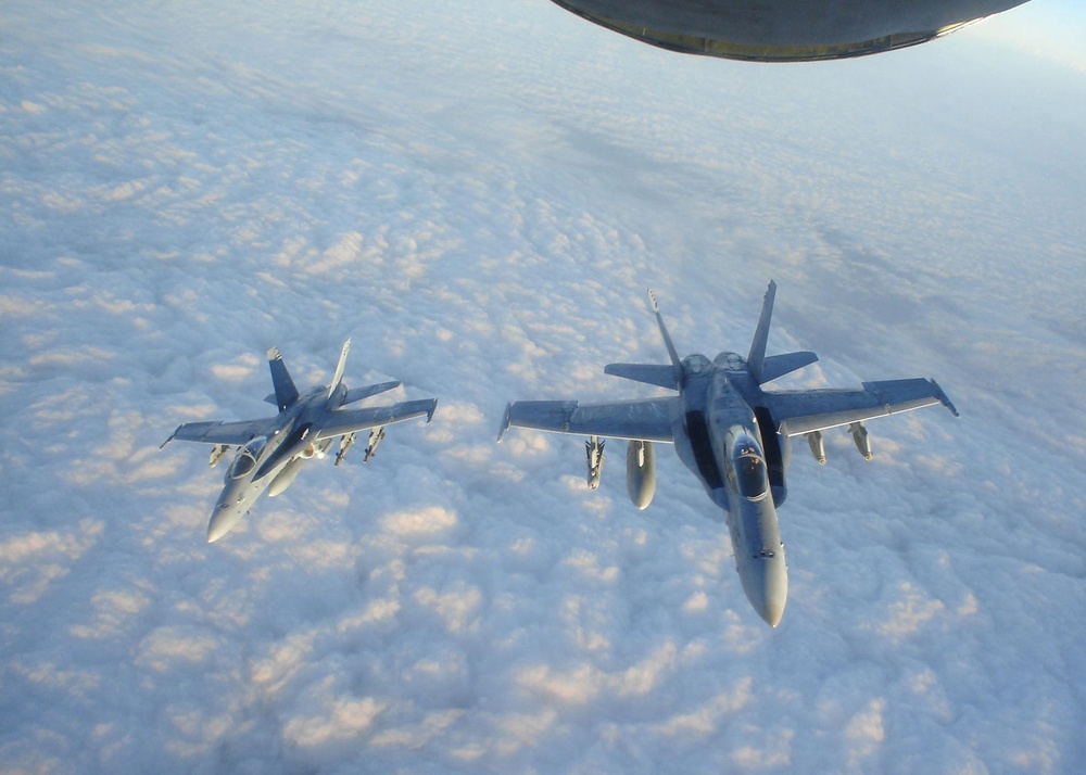 Two F/A-18C Hornet fly in formation after being refueled