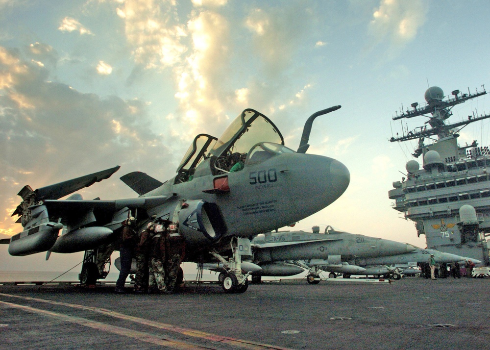 Sailors performs maintenance on an EA-6B Prowler