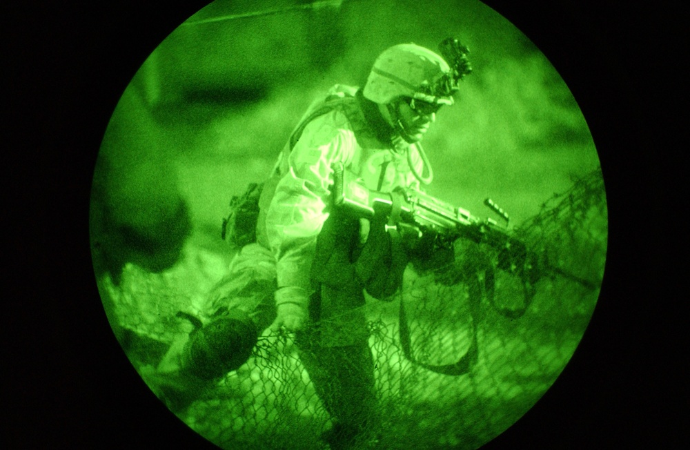 A Soldier moves over a fence into the yard