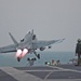 Flight deck personnel watch as an F/A-18C Hornet launch