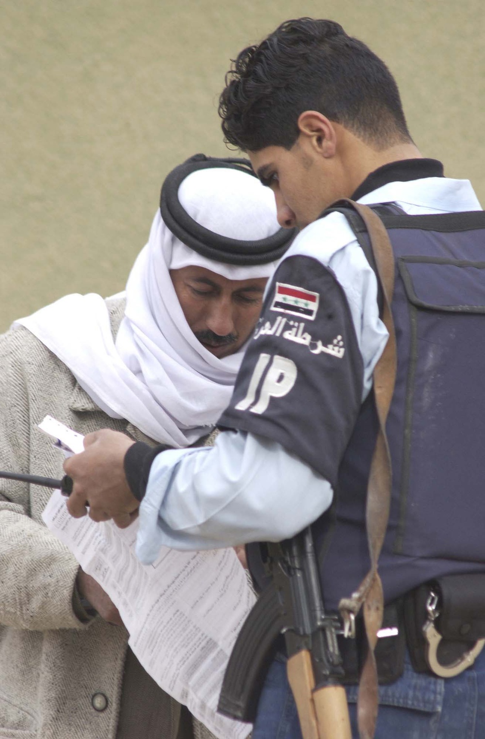 An Iraqi policeman helps explain how to use the ballot