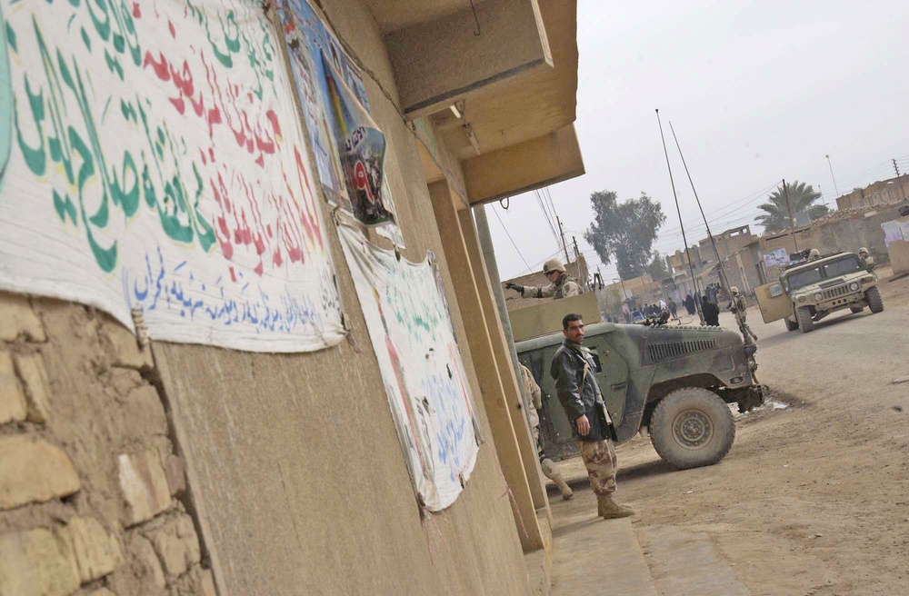 An Iraqi policeman stands guard near a perimeter