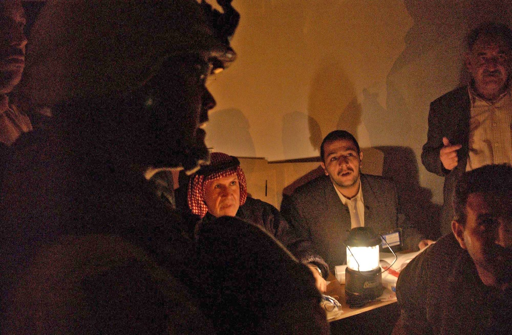 Capt. Henry Delacruz speaks with Iraqi polling workers
