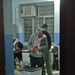 Iraqi polling center workers secure a box of ballots