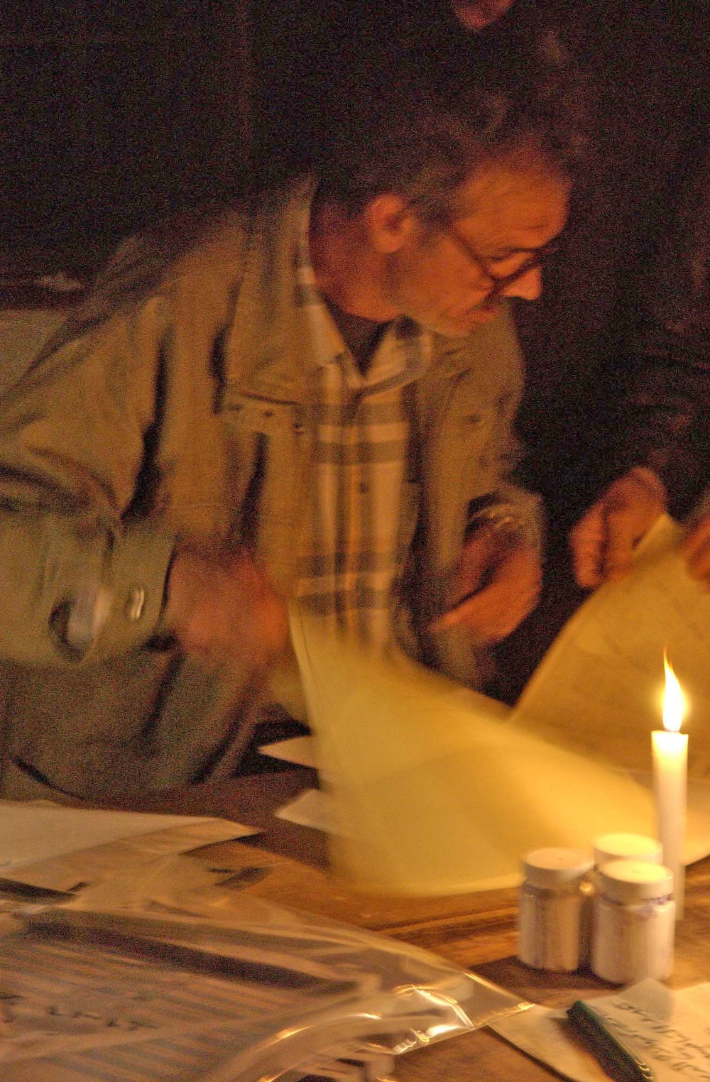 A Iraqi polling center worker goes through the last ballots
