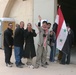 Iraqi citizens line up outside the polling station