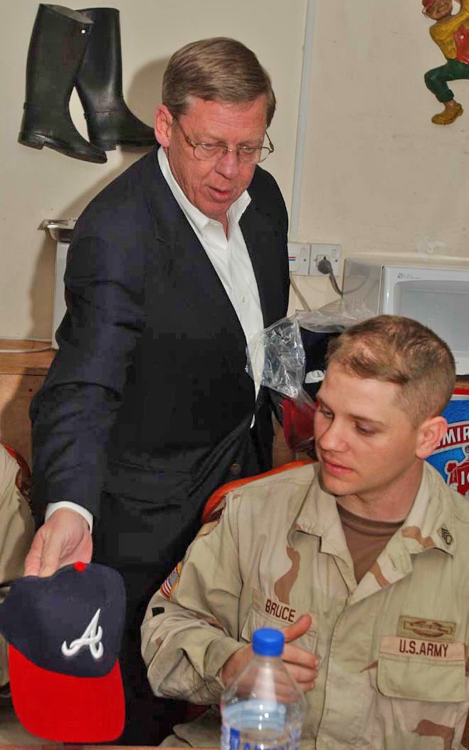 Senator Johnny Isaacson gives SSgt. Bruce a cap