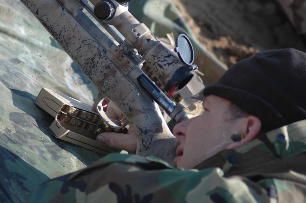 SSgt. Mike Ellis reaches to reload his M24 Sniper Weapon