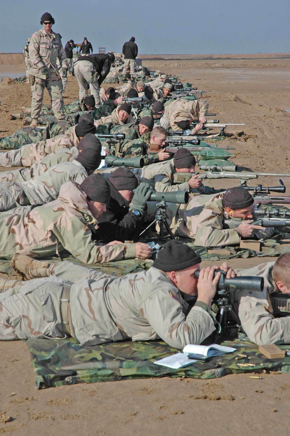 An instructor with the Sniper School watches over Soldiers