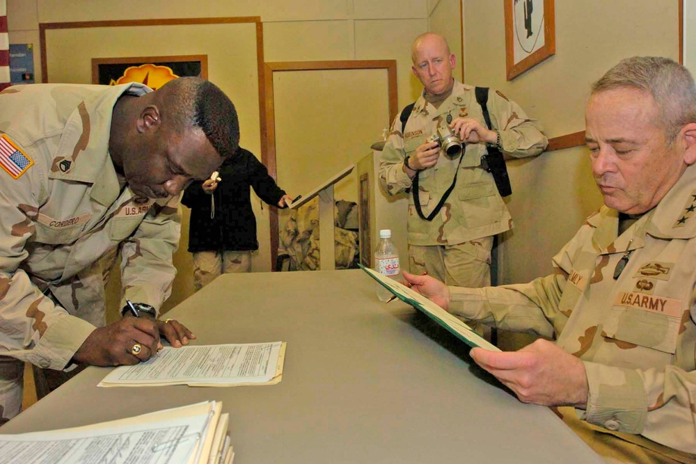 Staff Sgt. Lidel Cordero signs re-enlistment papers