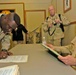 Staff Sgt. Lidel Cordero signs re-enlistment papers