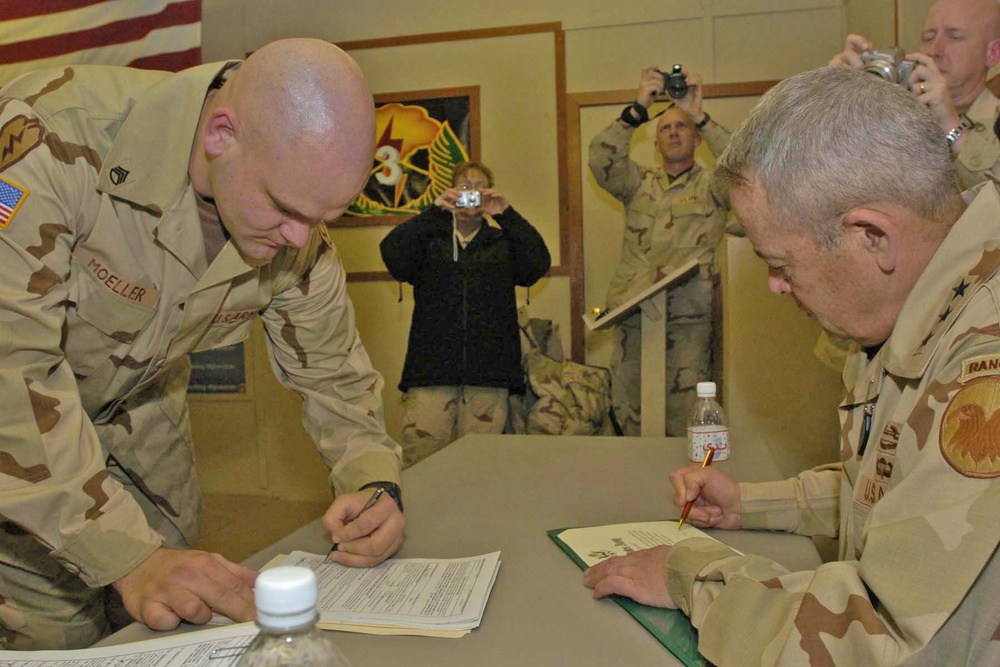 Staff Sgt. Clay Moeller signs re-enlistment papers