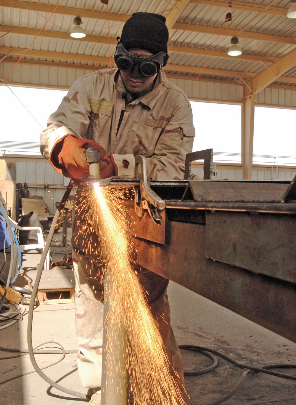 Spc. Christian Mena uses a plasma cutter