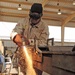 Spc. Christian Mena uses a plasma cutter