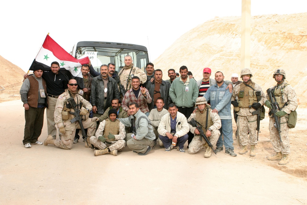 Iraqi citizens and U.S. service members take a group photo