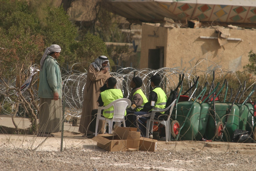 Iraqi civilians exit the voting area