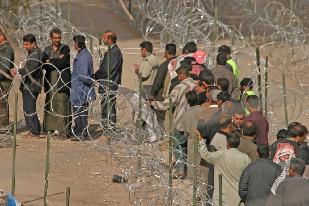 Iraqi civilians line up to vote at the Humanitarian Aid Site