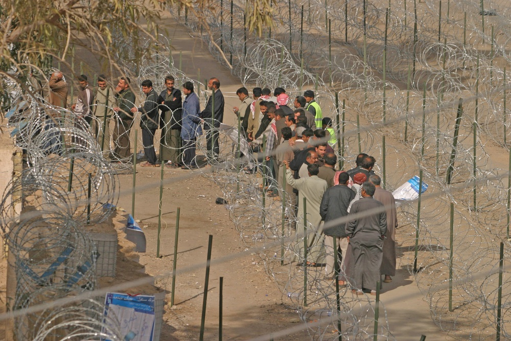 Iraqi civilians line up to vote at the Humanitarian Aid Site