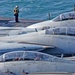 A sailor looks over the side railing while the ship is underway