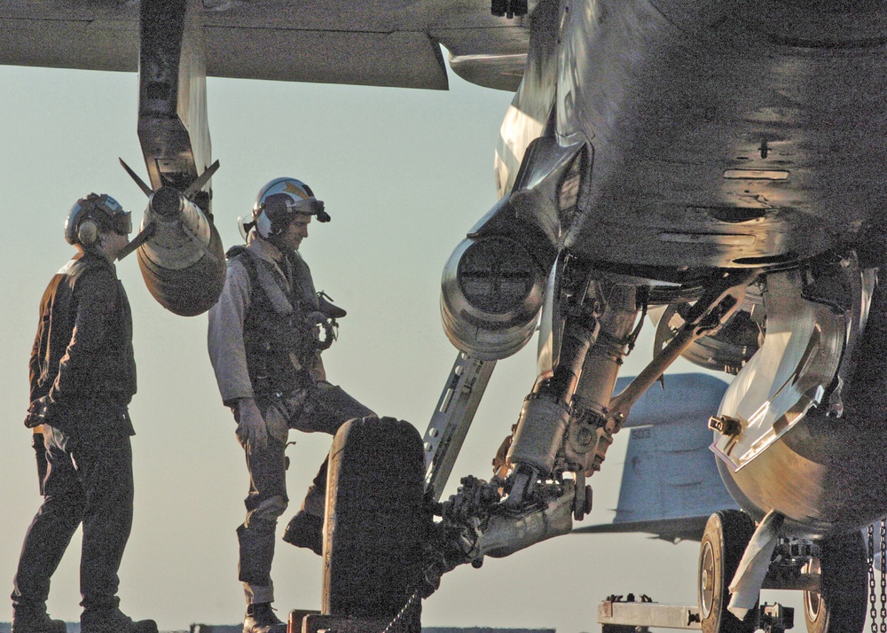 A pilot enters his aircraft prior to flight operations