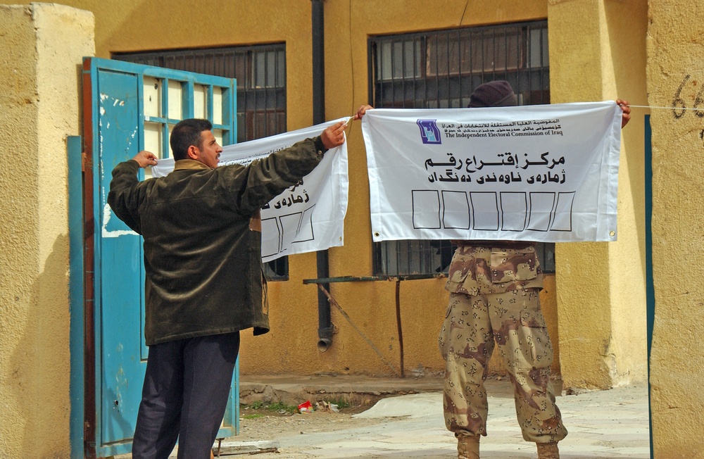 An Iraqi National Guardsman holds one sign