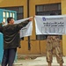 An Iraqi National Guardsman holds one sign