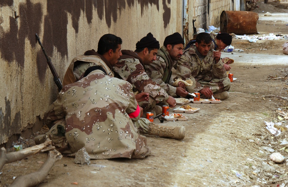 Members of the Iraqi National Guard eat in shifts