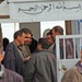 Iraqi voters talk while they wait inside of a polling station