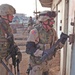 Spc. Kovach uses a hooligan bar to pry open the lock of a shed